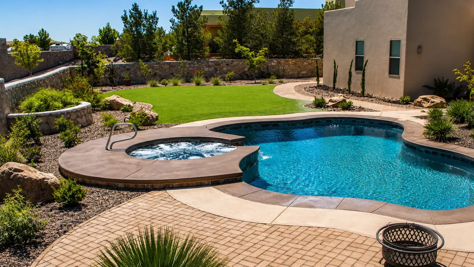 Backyard with a fiberglass pool and spa, paver deck, green lawn, and desert landscaping by Garden Center of Las Cruces in Las Cruces, NM Backyard with a fiberglass pool and spa, paver deck, green lawn, and desert landscaping by Garden Center of Las Cruces in Las Cruces, NM