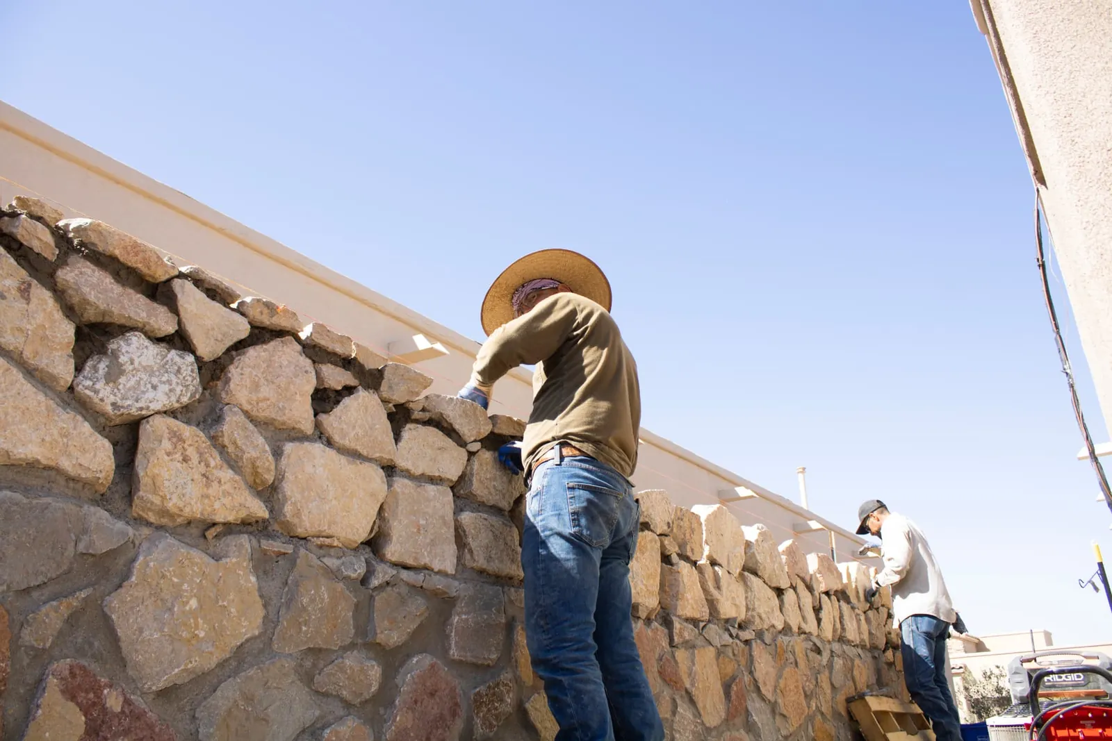 Garden Center of Las Cruces crew building a natural stone retaining wall under a clear blue sky in Las Cruces, NM Garden Center of Las Cruces crew building a natural stone retaining wall under a clear blue sky in Las Cruces, NM