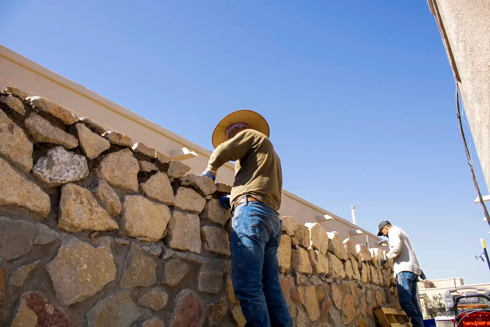 Garden Center of Las Cruces crew building a natural stone retaining wall and paver patio on a Las Cruces job site Garden Center of Las Cruces crew building a natural stone retaining wall and paver patio on a Las Cruces job site